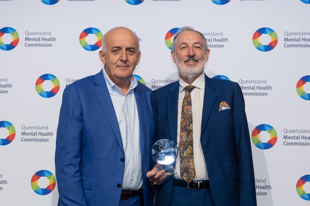 Associate Professor John Allan standing with Commissioner Ivan Frkovic receiving the award